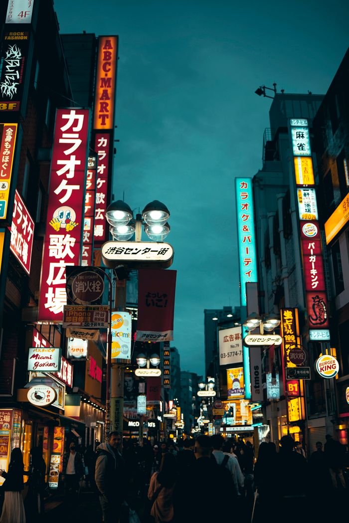 Bustling Shibuya street scene in Tokyo's nightlife with neon signs and pedestrians.